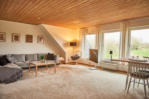 a living room with a couch and a table at Stylish vacation home - close to sea and nature in Hejls