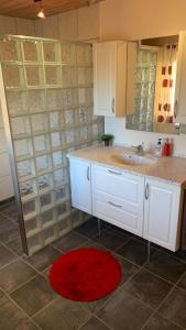 uma cozinha com armários brancos e um tapete vermelho em Stylish vacation home - close to sea and nature em Hejls