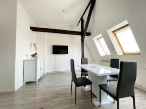ein Esszimmer mit einem weißen Tisch und Stühlen in der Unterkunft Komfortables Apartment nahe Hafen in Wismar
