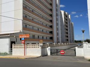 a street sign in front of a large building at Apartamento en Peñiscola a 3 minutos andando a la playa con parking in Peniscola