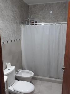 a bathroom with a toilet and a shower curtain at El mejor descanso in Plottier