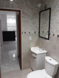 a bathroom with a toilet and a sink and a mirror at El mejor descanso in Plottier