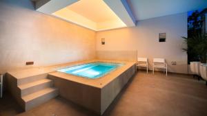 a hot tub in a room with stairs and aitating at Metria Hotel in León