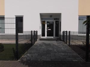 um edifício branco com uma porta e uma cerca em MyHome10 Wiesbaden-Mainz em Wiesbaden