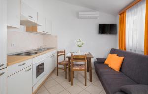 a kitchen and a living room with a couch and a table at Stunning Apartment In Porec With Outdoor Swimming Pool in Poreč