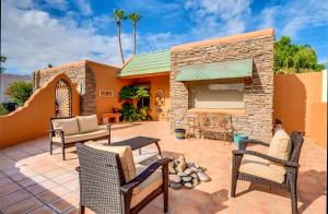 a patio with chairs and a brick fireplace at Tranquil oasis near Old Town, hot tub, mountain views in Scottsdale