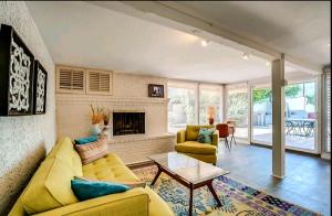 a living room with a yellow couch and a fireplace at Tranquil oasis near Old Town, hot tub, mountain views in Scottsdale