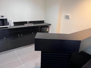 a kitchen with a black counter and a sink at Alcamo Motel in Hamilton