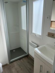 a bathroom with a shower with a glass door at MOBIL HOME VALRAS PLAGE LES SABLES DU MIDI in Valras-Plage