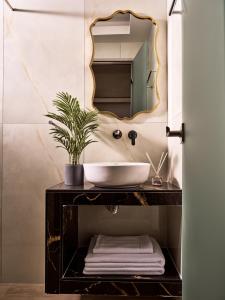 a bathroom with a sink and a mirror at Athina Studios in Laganas