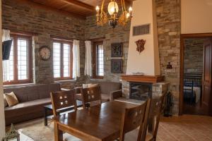 a living room with a table and a fireplace at Notas Pelion Seaview Villa in Zagora