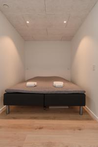 a bed in a room with two towels on it at Brand New / Airport / RentYourCar / Free Parking in Miðvágur