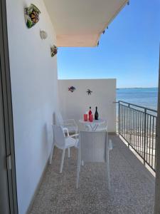ein Esszimmer mit einem Tisch, Stühlen und Meerblick in der Unterkunft Viva Vista Mare Trilo Primo Piano in Porto Cesareo