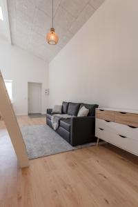 uma sala de estar com um sofá e uma cómoda em Brand New / Airport / RentYourCar / Free Parking em Miðvágur