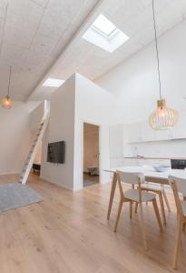 uma sala de estar branca com uma mesa e cadeiras em Brand New / Airport / RentYourCar / Free Parking em Miðvágur