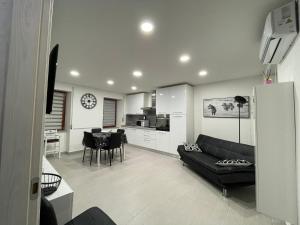uma sala de estar com um sofá preto e uma cozinha em Sweet C&C em Calangianus