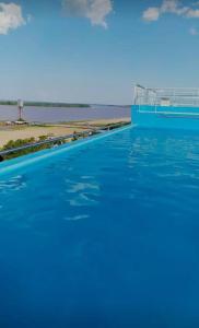 einen Pool mit blauem Wasser vor einem Strand in der Unterkunft Moderno monoambiente con vista al Río Paraná in Ramallo