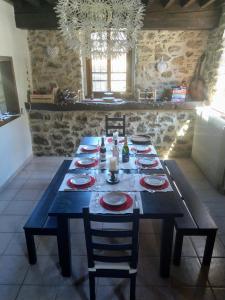 una mesa con platos rojos en la cocina en Les Ecuries, traditional stone farmhouse with pool en Marquixanes