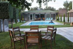 a table and chairs next to a swimming pool at Sunlit Pool House in Posidhonía