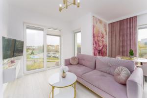 salon z fioletową kanapą i stołem w obiekcie Fredry 2 Apartament Liliowy w Kołobrzegu