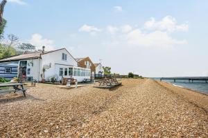 een strand met banken en een gebouw en het water bij North West Sea View No 3 in Yarmouth