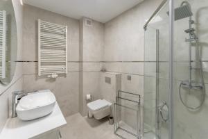łazienka z prysznicem, toaletą i umywalką w obiekcie Fredry 2 Apartament Liliowy w Kołobrzegu
