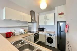 a kitchen with a sink and a refrigerator at Moana Studio - downtown Papeete - WiFi AC Netflix parking - 3 people in Papeete