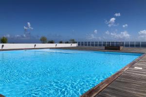 - une grande piscine bleue au-dessus d'un bâtiment dans l'établissement Kai cosy apartment with terrace pool and sea view near Papeete, à Fa'a'ā