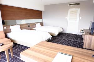 Postel nebo postele na pokoji v ubytování Kofu Kinenbi Hotel