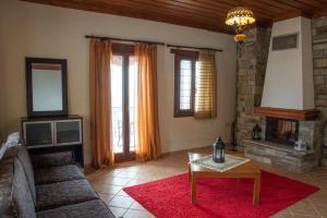 a living room with a couch and a fireplace at Notas Pelion Seaview Villa in Zagora
