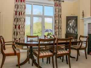a dining room with a table and chairs and a window at Huglith Farm in Habberley