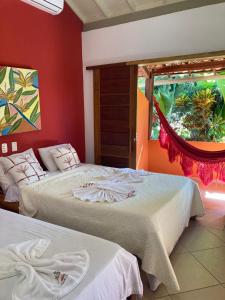 a bedroom with two beds and a window at Pousada Villa do Sol in Itacaré