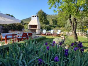 einen Garten mit einem Tisch, Stühlen und Blumen in der Unterkunft Apartment Garden, Korcula in Blato