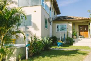 a house with a palm tree in front of it at L´Grace Geriba in Búzios
