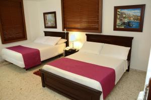 two beds in a hotel room with two beds sidx sidx sidx at Hotel Karlo By GHO Hoteles in Cali