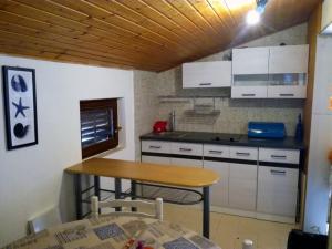eine kleine Küche mit einem Tisch und einer Arbeitsplatte in der Unterkunft Angela Apartments -Lopar in Lopar