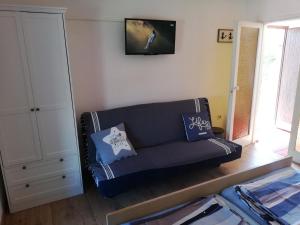 ein Wohnzimmer mit einer schwarzen Couch mit Kissen darauf in der Unterkunft Angela Apartments -Lopar in Lopar