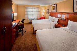 a hotel room with two beds and a desk at Sonesta Select Boston Danvers in Danvers