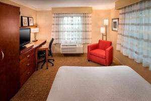 ein Hotelzimmer mit einem Schreibtisch und einem roten Stuhl in der Unterkunft Sonesta Select Boston Danvers in Danvers