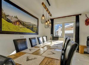 Alm'a Residence في كتسبويل: غرفة طعام مع طاولة وكراسي طويلة