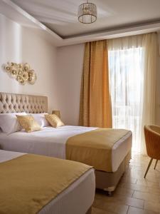 a hotel room with two beds and a window at Athina Studios in Laganas