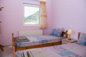 a bedroom with two beds and a window at Dimos-Mani Wonderful View in Limbókhova