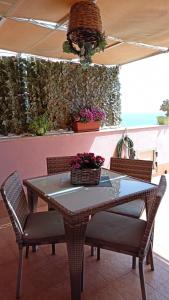 a dining room table with chairs and a plant wall at La Petite Maison in Aci Castello