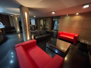 ein Wohnzimmer mit einem roten Sofa und einem Tisch in der Unterkunft Calandre Hotel in São Paulo