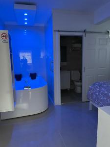 Cette chambre bleue comprend une salle de bains pourvue d'un lit et d'une baignoire. dans l'établissement Palmas View Premium 5, à Candelero Arriba