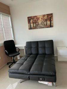 - un canapé en cuir noir dans une pièce avec une chaise dans l'établissement Palmas View Premium 5, à Candelero Arriba