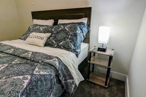 a bedroom with a bed and a side table with a lamp at AIR & ROAD TRAVELERS' PERFECT SPOT! + FULL KITCHEN in Regina