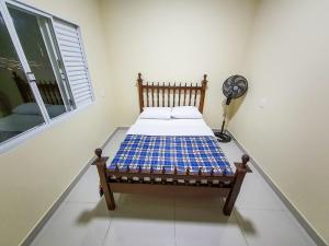 Cama en habitación con ventilador y ventana en Casa Canastra Bio, en São Roque de Minas