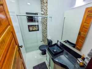 een badkamer met een wastafel, een toilet en een spiegel bij Casa Canastra Bio in São Roque de Minas
