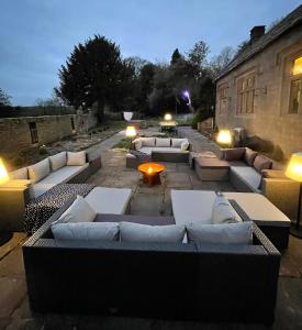 a group of couches sitting on a patio at night at Riber Hall in Matlock Bank